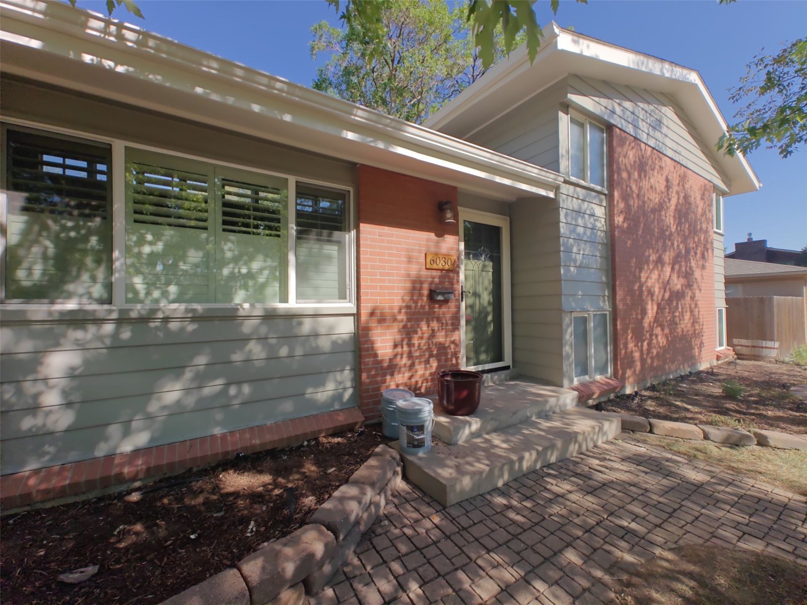 After: front entry of the Arvada home repainted in a warm modern greige with white trim