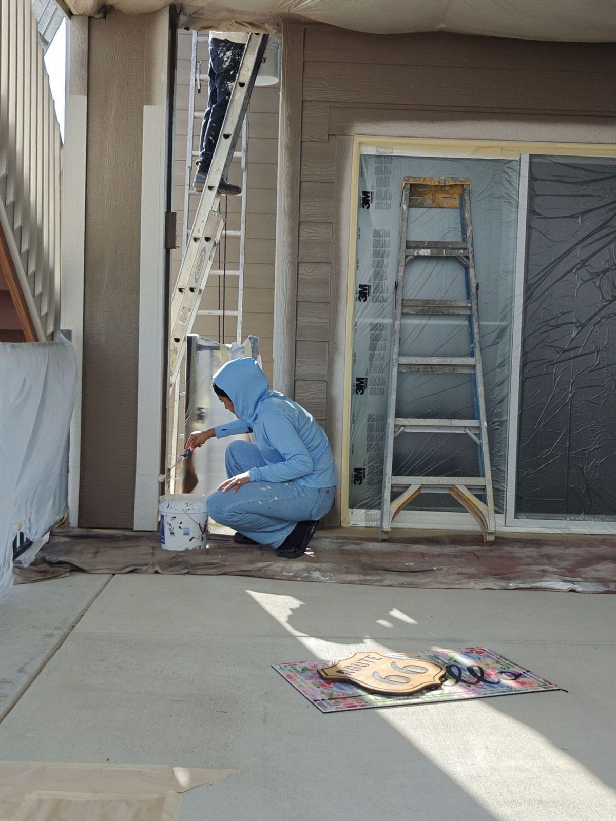 Painter masking and prepping windows and trim before an exterior paint job near Wheat Ridge, Colorado