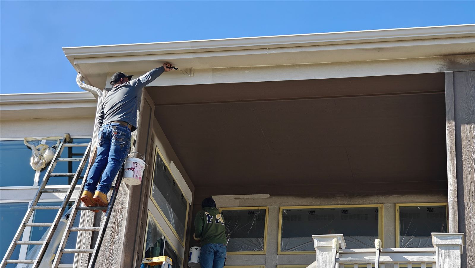 Painter finishing soffit and fascia trim on a home exterior near Westminster, Colorado